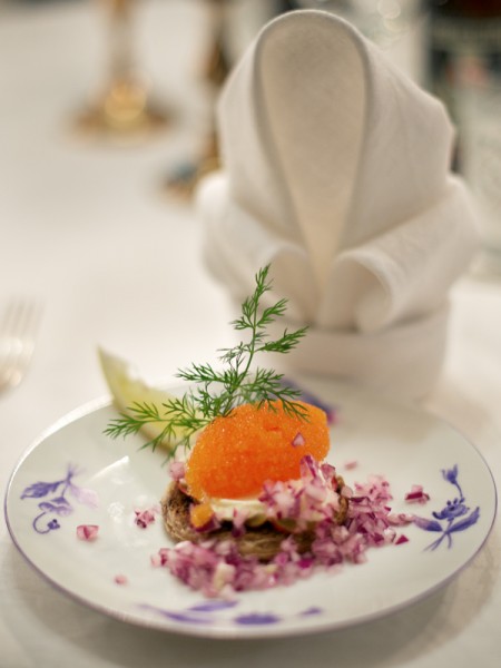 Vendace roe toast with a thin slice of apple and diced red onion