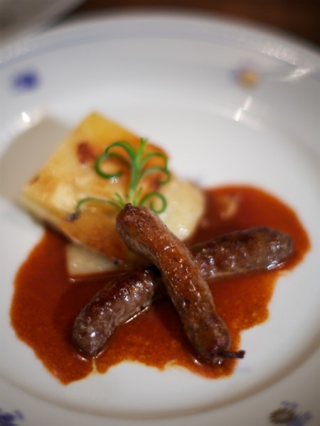 Red deer and stored cheese sausages with potato and chèvre gratin and red wine gravy